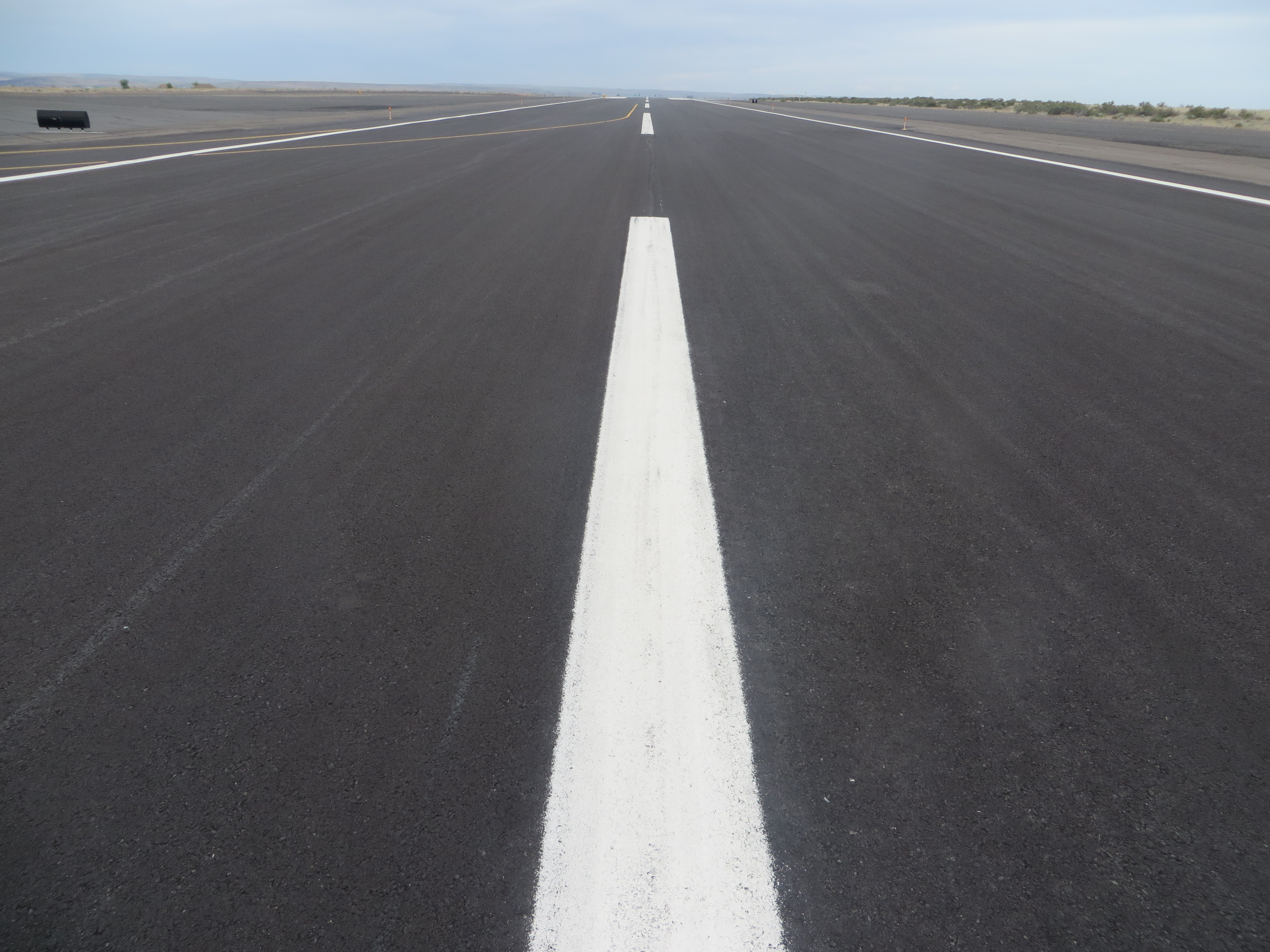 This picture shows an asphalt runway pavement with no distress.  The PCI of the pavement in the image is 100.